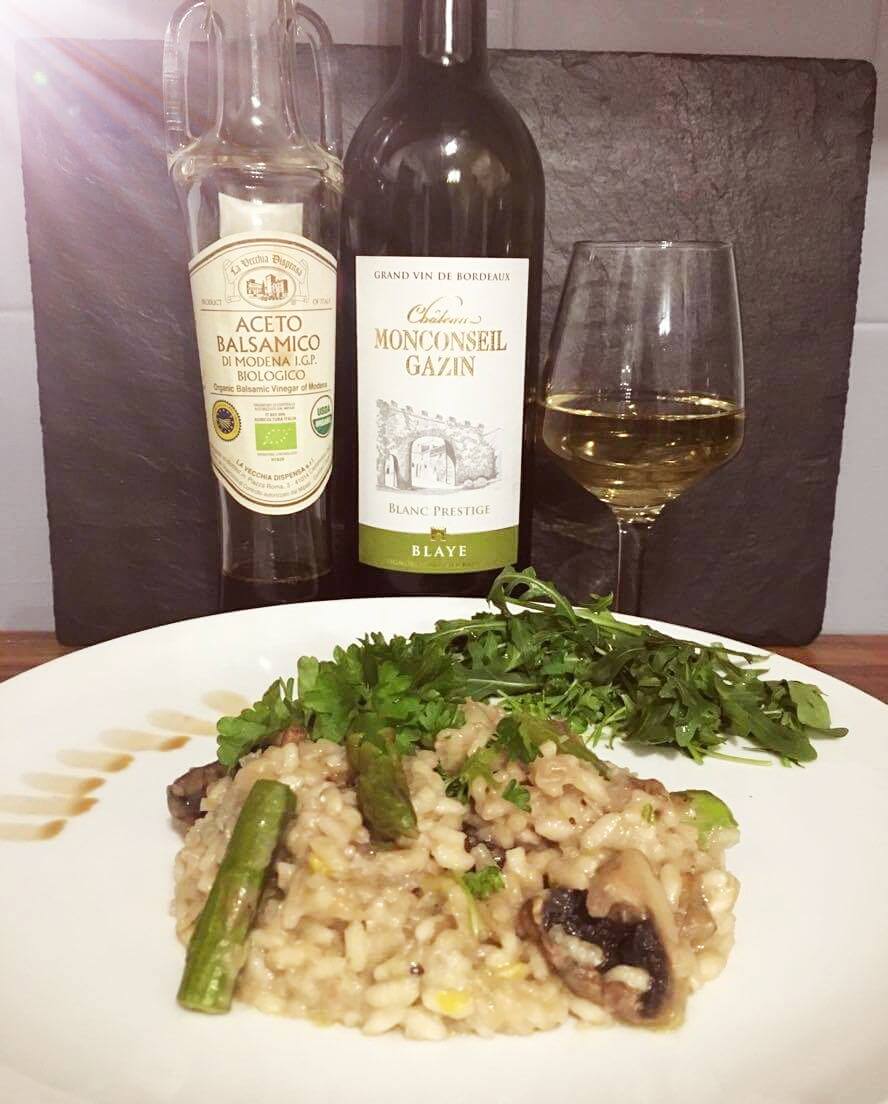 On this picture we can see a nice bottle of white wine and a delicious plate of Risotto